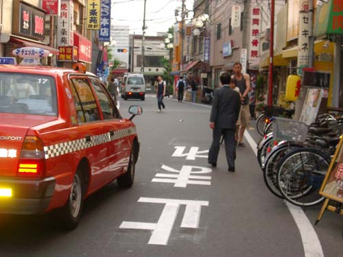 7a pedestrians bikes and cars in alley street in Jujo