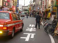 7a pedestrians bikes and cars in alley street in Jujo